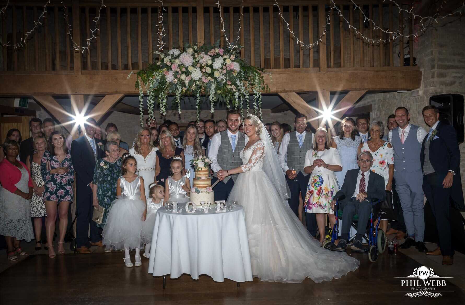 Kingscote Barn Wedding Photography bride and groom cutting wedding cake