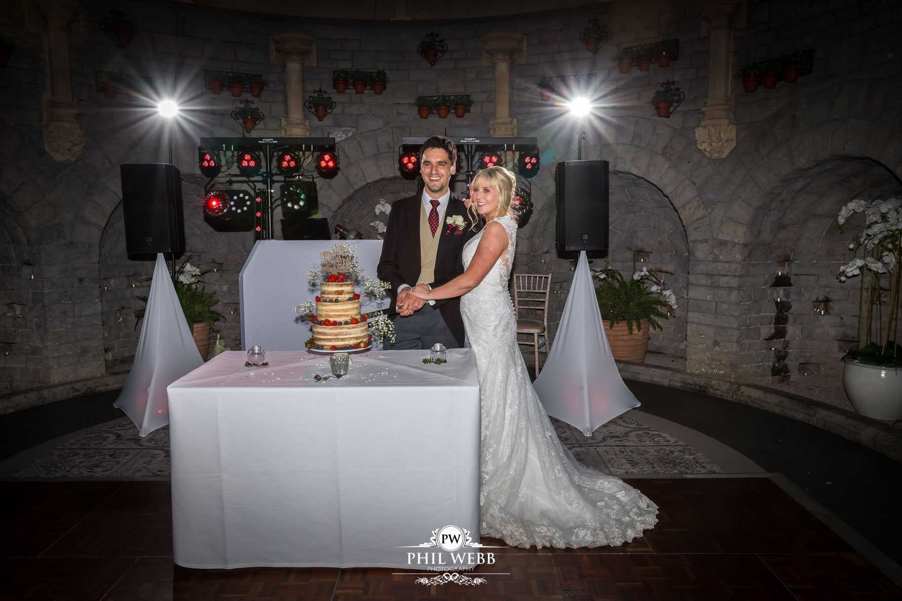 Tortworth Court Wedding Photography bride and groom cutting wedding cake
