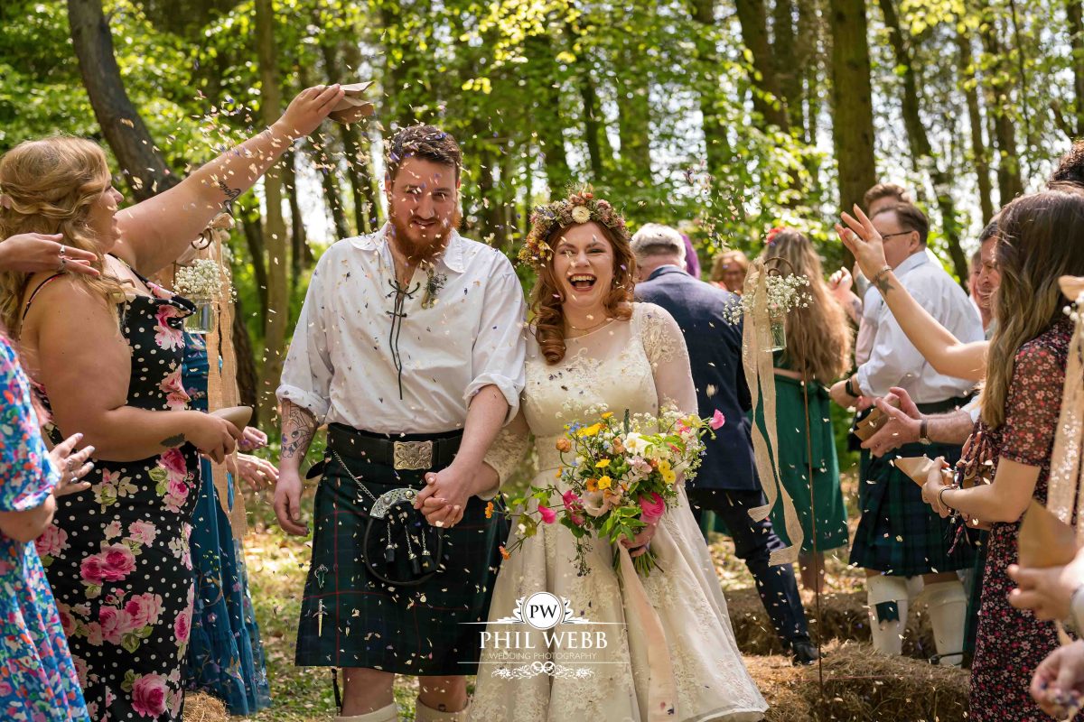 Enchanted Woodland Wedding Hereford bride and groom walking confetti