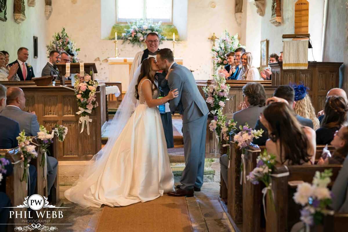 bride and groom first kiss in church