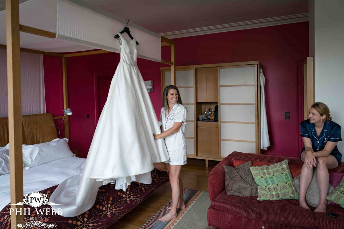 bride looking at their wedding dress in the morning of the wedding