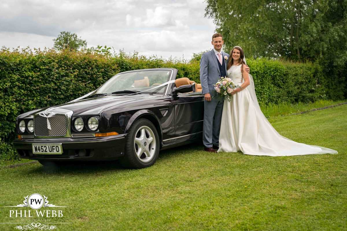 Bride and Groom Portrait next to wedding Bentley car