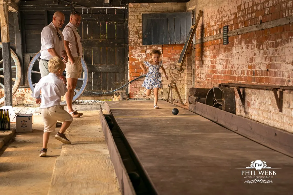 Over barn at Over Farm Wedding Photography guests playing skittles