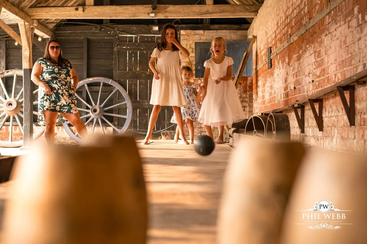 Over barn at Over Farm Wedding Photography guests playing skittles