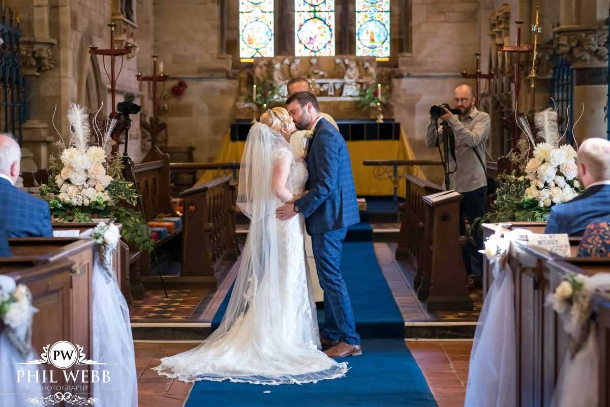 bride and groom wedding ceremony first kiss in church