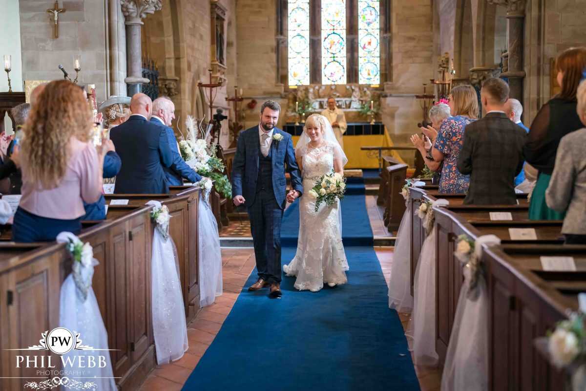bride and groom wedding ceremony in church walking down the aisle