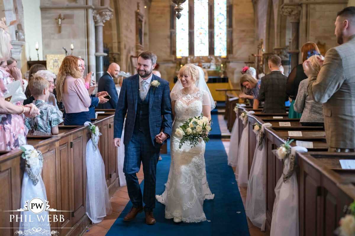 bride and groom wedding ceremony in church walking down the aisle
