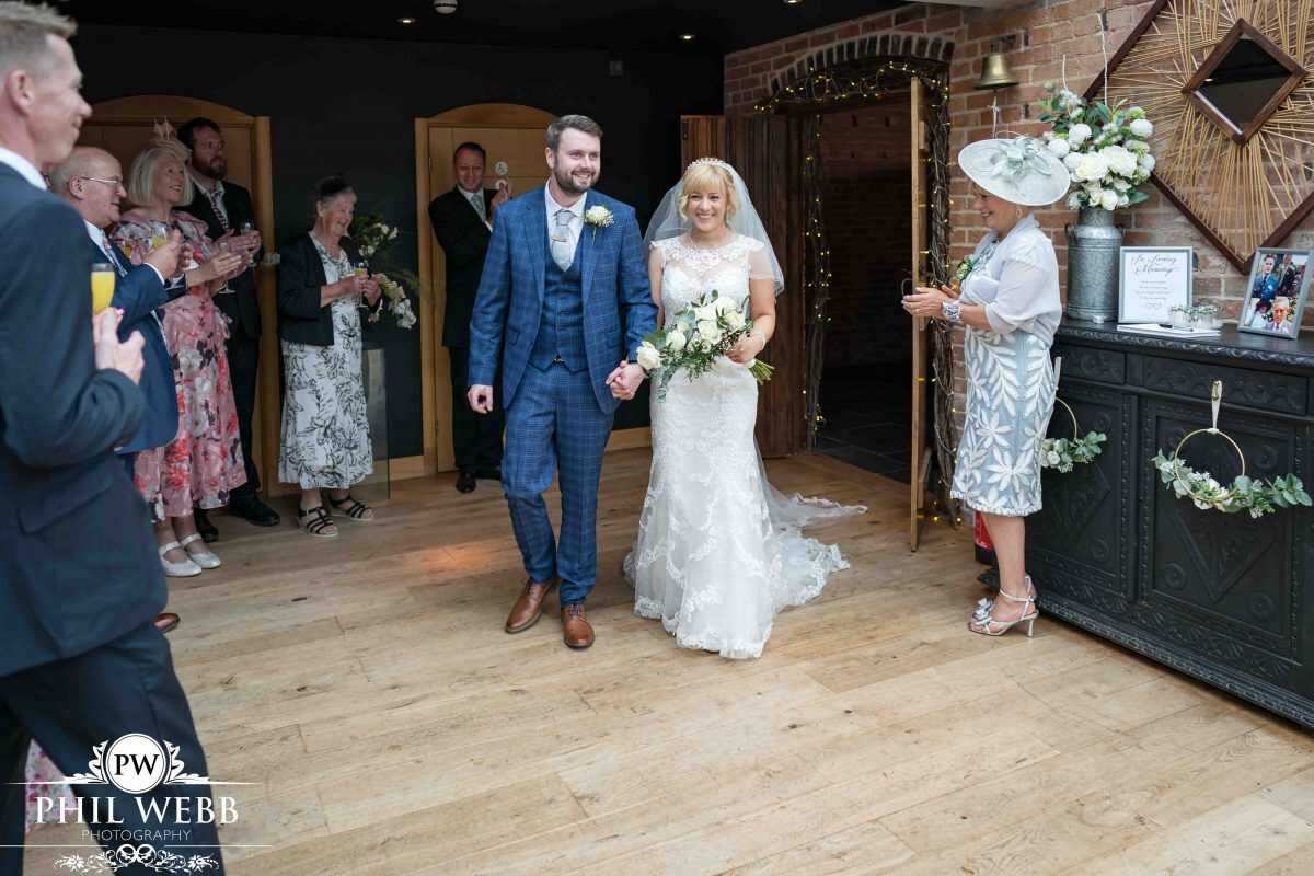 bride and groom walking into reception